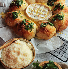 Käse-Schinken-Brötchen, gefüllt mit Camembert und Schinken, gebacken bis goldbraun und serviert mit geschmolzenem Ofenkäse.