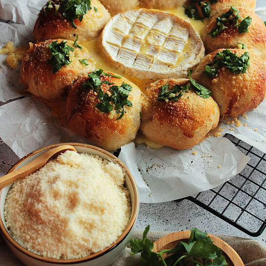 Käse-Schinken-Brötchen, gefüllt mit Camembert und Schinken, gebacken bis goldbraun und serviert mit geschmolzenem Ofenkäse.