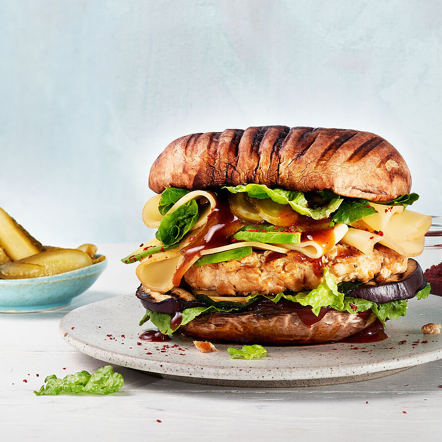 Portobello Burger belegt mit Hähnchen, Zucchini, Aubergine und Fol Epi Käse als runden Abschluss