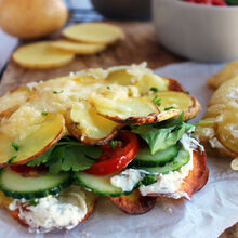 Knusprige Kartoffel-Wraps, gefüllt mit BRESSO Kräuterfrischkäse, Kirschtomaten, Gurkenscheiben und Petersilie.