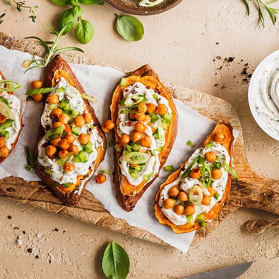 Veganer Bresso auf gerösteten Süsskartoffeltoast, mit frischen Frühlingszwiebeln und Kichererbsen