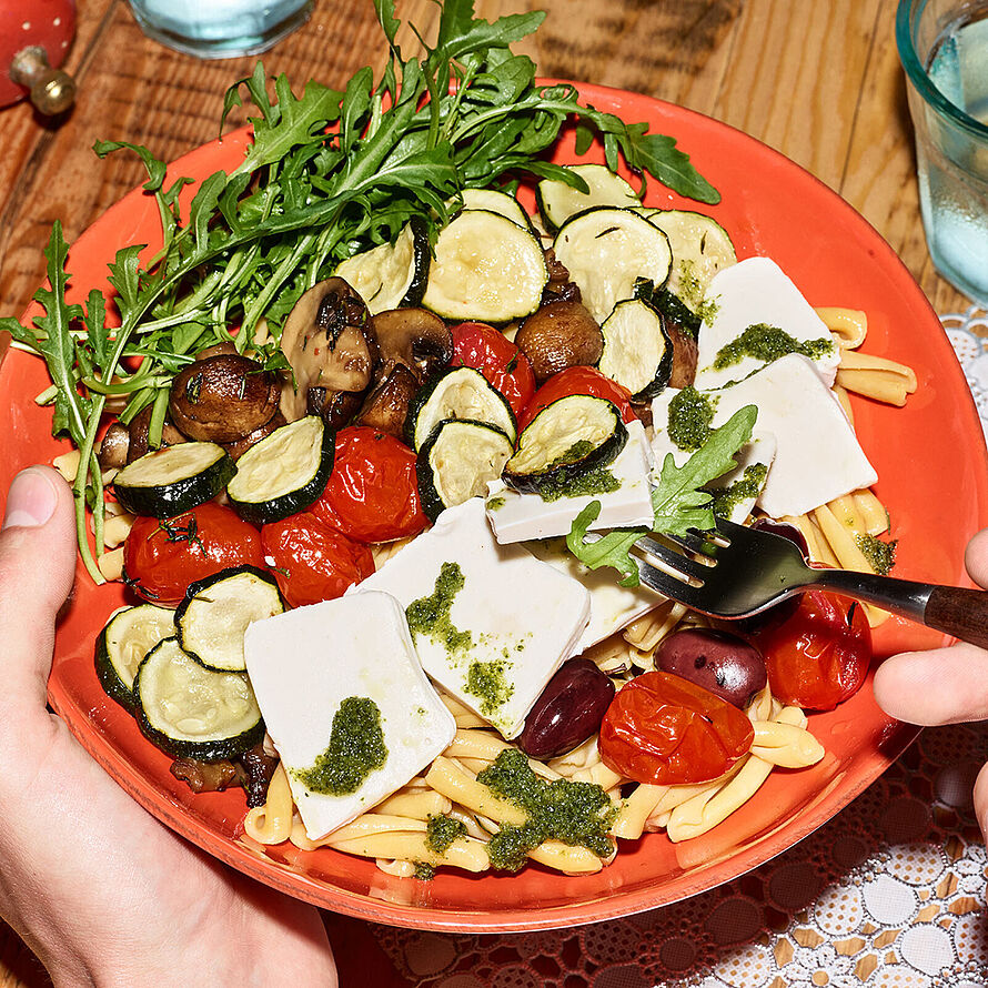 Mediterrane Ofengemüse in einer roten Schüssel mit gebratenen Champignons, Tomaten, Zucchini und HOPE Cremozza