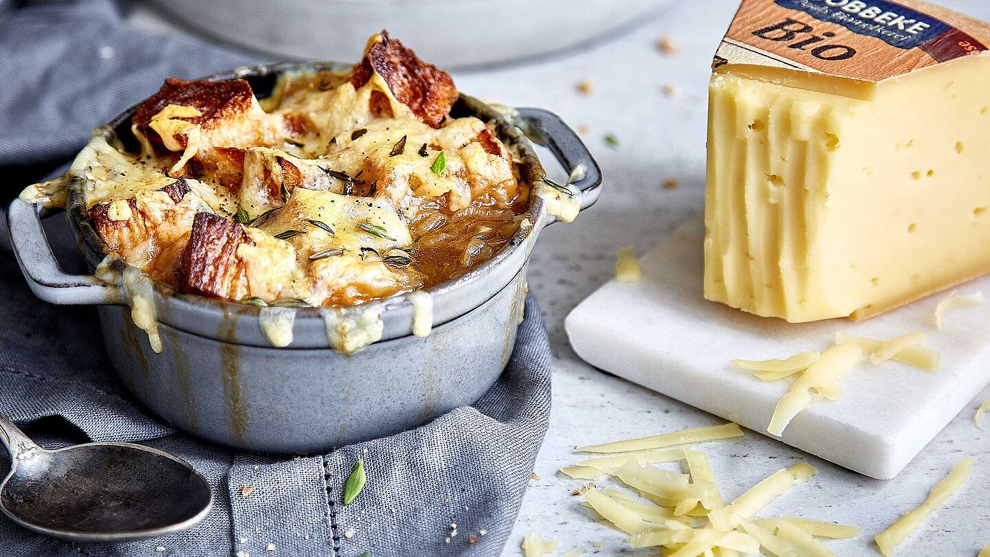 Deftige Zwiebel-Altbier-Suppe mit Käse überbacken, verfeinert mit Knoblauch und Thymian