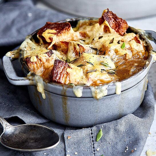 Deftige Zwiebel-Altbier-Suppe mit Käse überbacken, verfeinert mit Knoblauch und Thymian