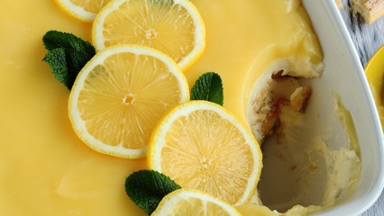 Ein frisch zubereitetes Zitronen-Tiramisu mit Limoncello in einer weißen Auflaufform, garniert mit Zitronenscheiben und Minzblättern.