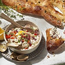 Cremiger Dip aus gegrilltem Gemüse, serviert mit knusprigem Fougasse-Brot. Das Dip besteht aus einer Mischung aus gegrilltem Paprika, Auberginen, Zucchini 