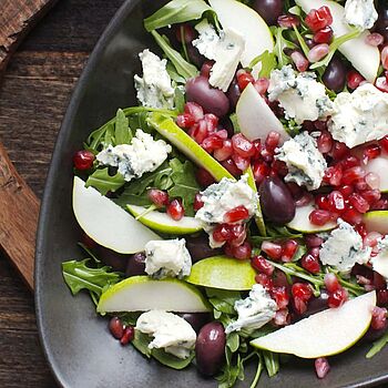 Fruchtig-würzige Salat-Überraschung mit Saint Agur, Granatapfel und Oliven. Perfekte Salatbeilage für Grillabende