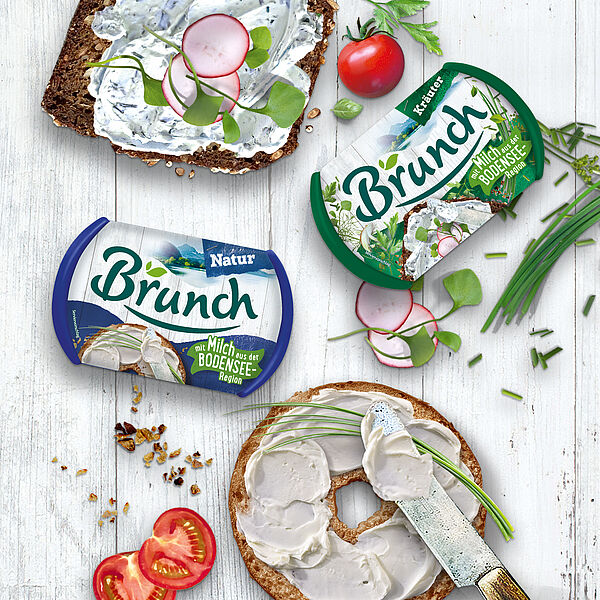 Tisch von oben mit zwei Packungen Brunch, zwei Brotscheiben und Zutaten