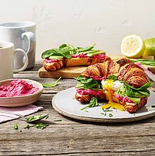 Laugencroissant mit einem pochierten Ei, Feldsalat, Schnittlauch und Brunch Rote Beete.