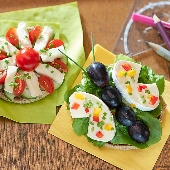 Für Groß und Klein! Pausenbrot aus Tomaten, Trauben, Salat und Géramont Minis als Schmetterling und Blüte zubereitetals 