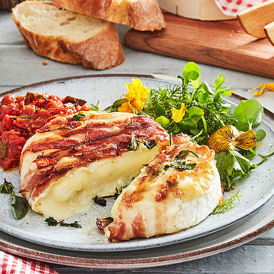 Camembert mit Kräutern – Die Kombination aus der knusprigen Kräuterkruste, dem salzigen Speck und der weichen, cremigen Käsefüllung ist einfach unwiderstehlich.