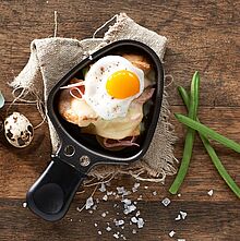 Rustikales Raclette Pfännchen mit Speck, Zwiebeln, Spiegelei, Bohnen und würzigen Käse