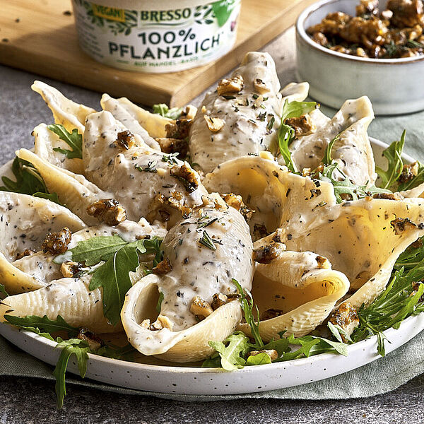 Vegane Pasta Provence mit cremiger Sauce, garniert mit Rucola und Walnüssen.