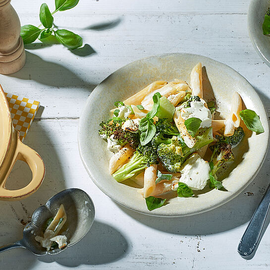 Mediterran zubereitete Pasta mit Brokkoli garniert mit frischen Basilikum Blättern