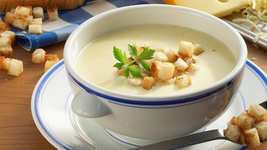 Vegetarische Suppe, garniert mit frischen Kräutern und Croûtons. 