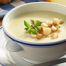 Vegetarische Suppe, garniert mit frischen Kräutern und Croûtons. 