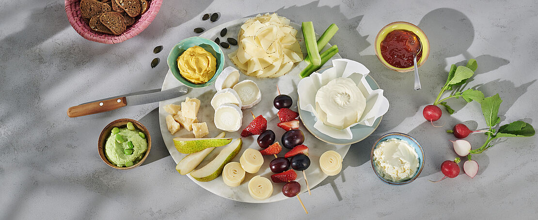 Käseplatte aus ausgewählten Käsesorten, die auch werdende Mütter bedenkenlos genießen können. Serviert mit Früchten und Gemüse.
