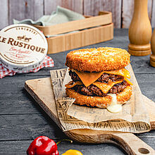 Goldbraun panierter Camembert, kombiniert mit saftigem Rinderhack und britischem Cheddar, perfekt zu einem Burger geschichtet.