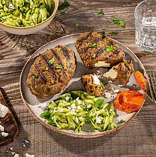 Griechisches Bifteki aus Rinderhack gefüllt mit Ziegenkäse. Dazu wird Zucchini-Slaw mit Paprika-Tomaten Creme serviert. 