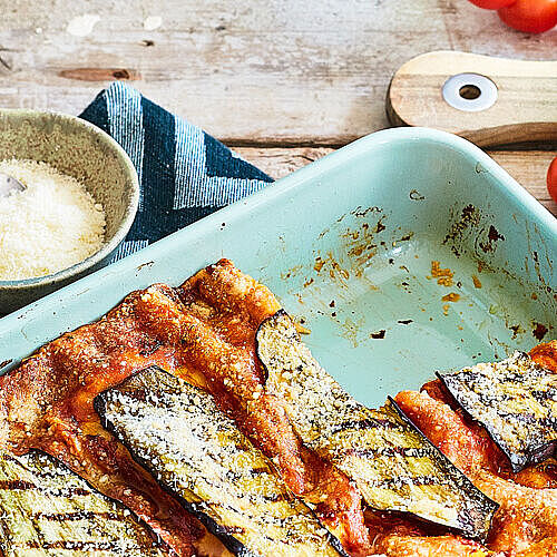 Auflaufform gefüllt mit vegetarischer Lasagne aus Auberginen und überbacken mit Parmesan