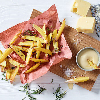 Pommes aus echten Kartoffeln mit selbst gemachter Käsesauce aus Emmentaler und frischem Rosmarin gewürzt. 