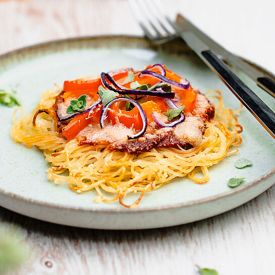 Spaghetti Pizza, so köstlich wie noch nie! Mit frisch geriebenem Parmigiano Reggiano, roten Paprika, Champignons und Oliven, gebacken in goldgelb. Ein Traum!