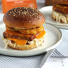 Burger Rezept – Herzhafte Leberkäse-Burger mit Kartoffelrösti, Cheddar, Krautsalat und süßem Senf auf gerösteten Laugenbrötchen.