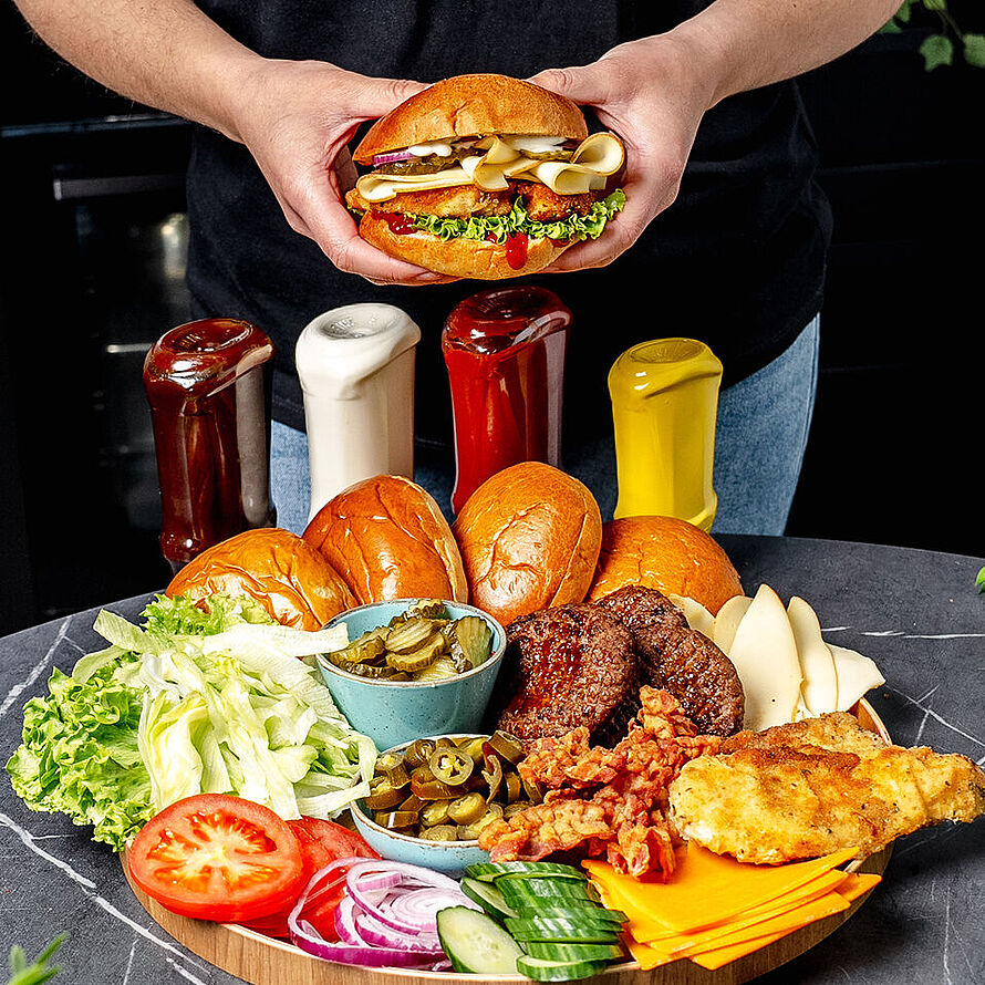 Ein leckeres Burger Board mit saftigen Patties, frischem Gemüse und zwei Sorten hochwertigem Käse, ideal für jede Party.