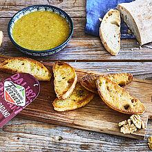 Dreierlei Pestovarianten mit Parmesan, dazu knusprige Crostini auf einem rustialen Holzbrett