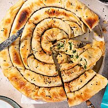 Griechische Spanakopita gefüllt mit Feta, Reis, Spinat, Mandeln in Filoteig gebacken.