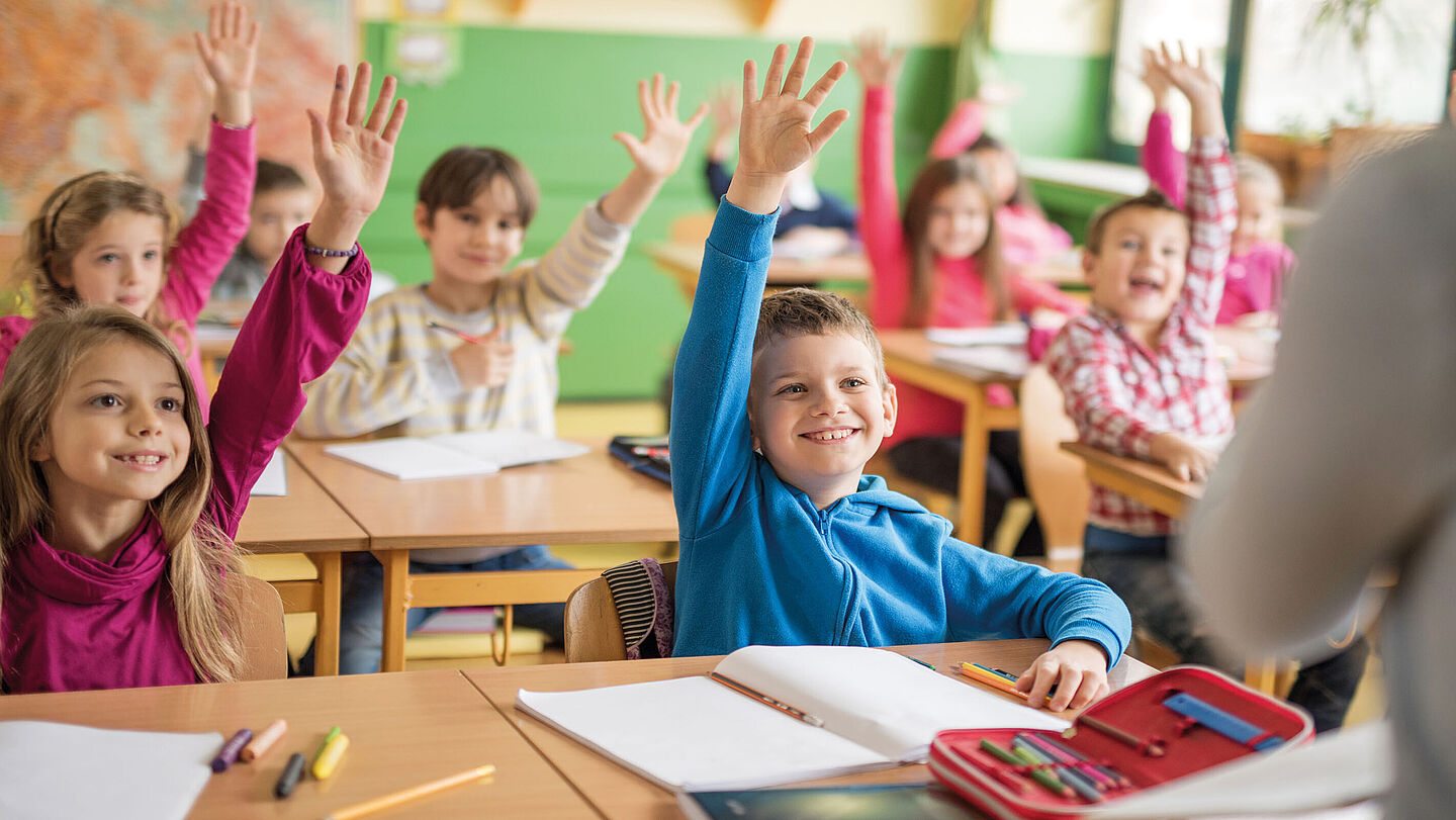 Eifrige Schüler, die sich im Unterricht melden. 