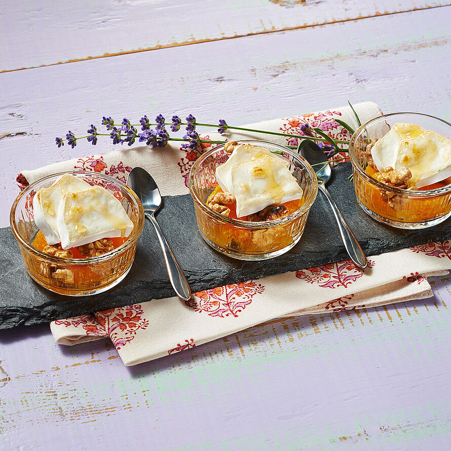 Orangen Dessert mit Walnüssen und Käse in kleinen durchsichtigen Schüsseln drapiert auf einer Schieferplatte 