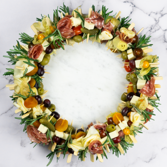 Festlicher Charcuterie Adventskranz mit Käse, Wurst und Früchten – Dekoriert mit Rosmarinzweigen.