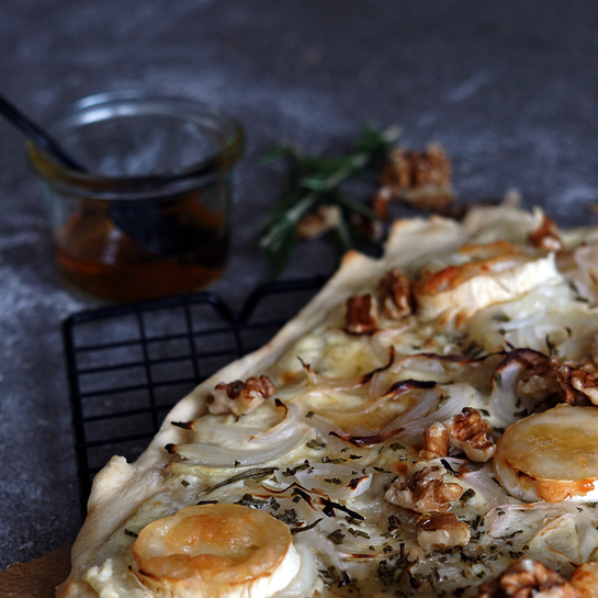  Flammkuchen mit knusprigem Teig, garniert mit Chavroux-Ziegenkäse, Walnüssen, Zwiebeln und einem Hauch von Honig