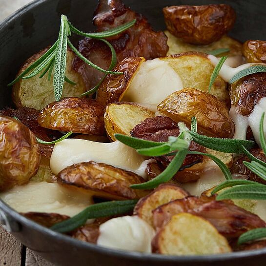 Rezept für Rosmarinkartoffeln mit Käse, Räucherspeck und frischem Rosmarin.