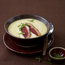 Maiscremesuppe garniert mit Lauchzwiebeln und Entenbrustscheiben auf Basis von Hühnerbrühe. 