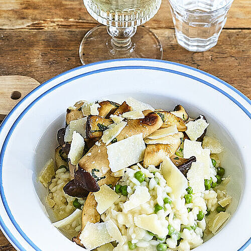 Herbstlich angerichtetes Erbsenrisotto mit Grana Padano Parmesan und frischen Kräuterseitlingen