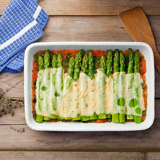  Große Auflaufform mit frischem grünen Spargel aus dem Backofen. Mit Käse überbacken in Tomatensoße. 